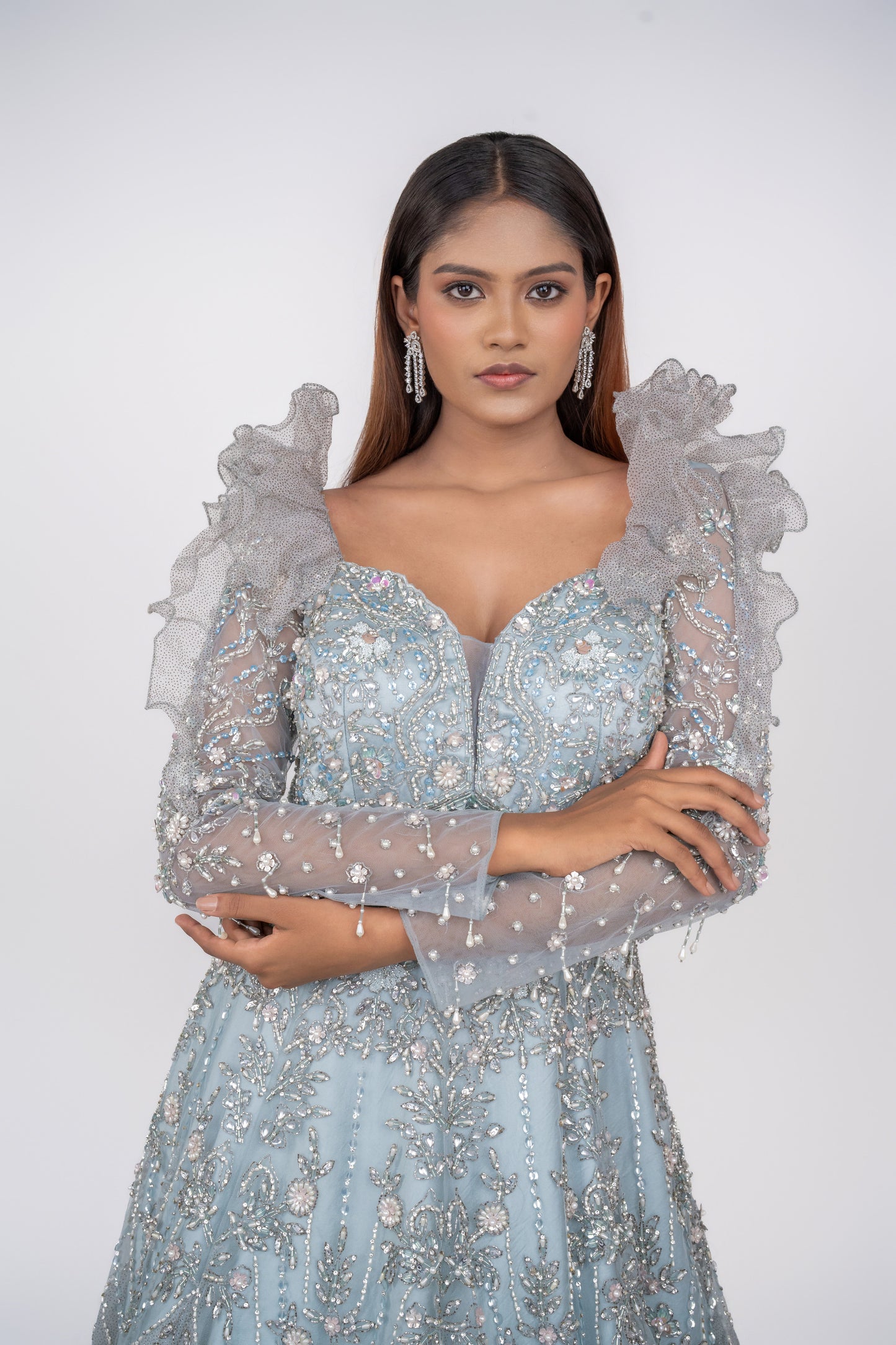 designer net gown with heavy work and sequin work and ruffle pattern on shoulders.