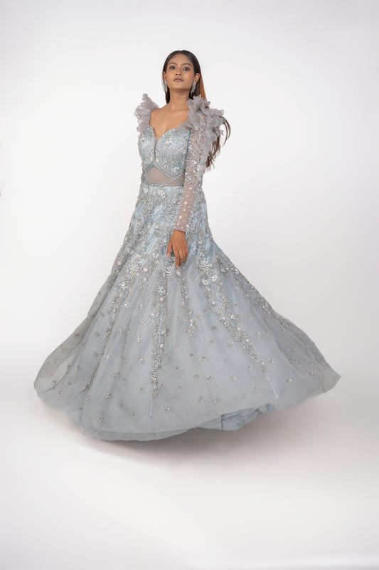 designer net gown with heavy work and sequin work and ruffle pattern on shoulders.
