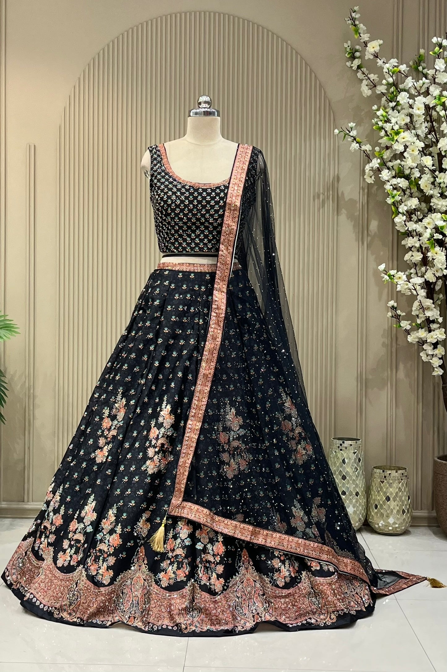 Black lehenga set showing scattered floral print and coral paisley border