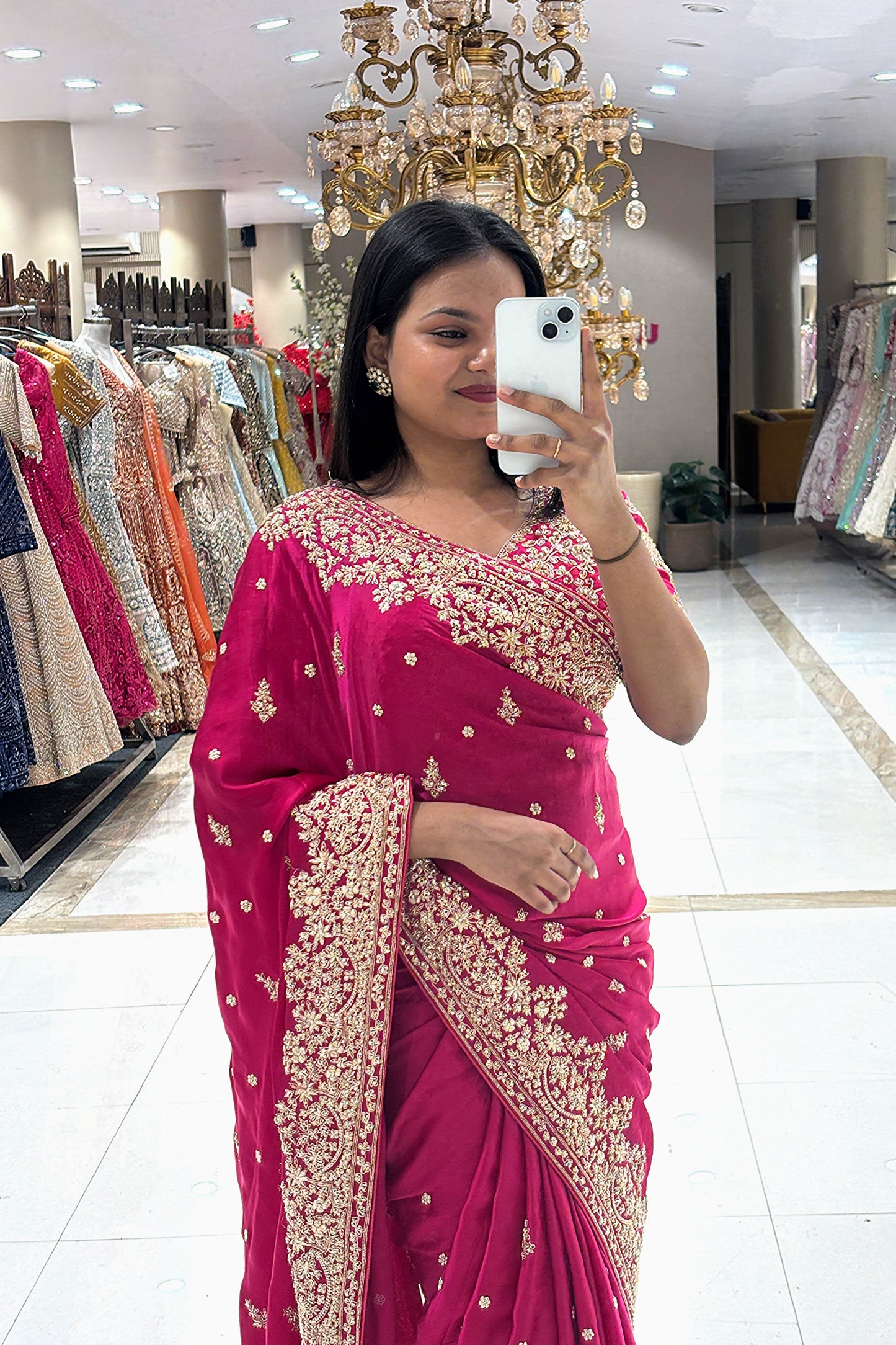 Close-up of a premium pure handwork fuchsia pink party wear saree highlighting intricate gold zardosi and floral embroidery along the drape and neckline.