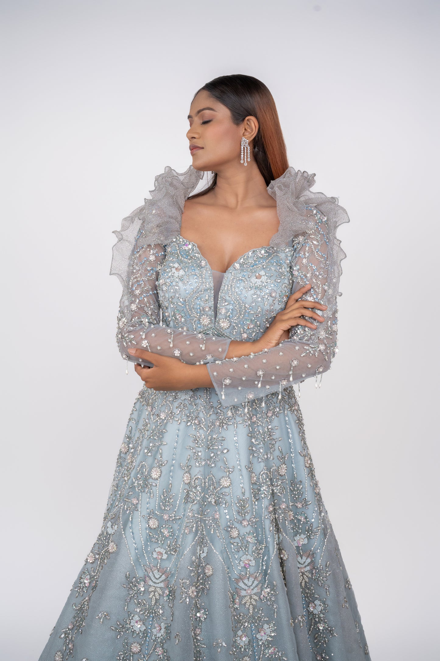 designer net gown with heavy work and sequin work and ruffle pattern on shoulders.
