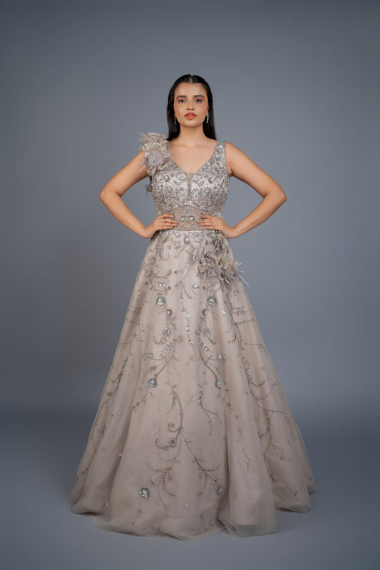 Floor-length voluminous dusky grey designer gown with feather touch and heavy handwork.