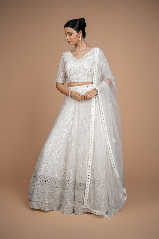 Front view of a luxurious white bridal lehenga featuring heavy handwork and ornate border by Urban Dulhaniya