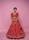 Bride wearing heavy red silk designer lehenga with Cutdana, pearl and zarkan handwork
