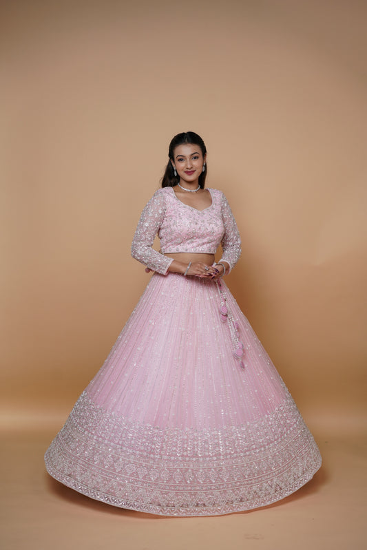 Bride wearing an elegant baby pink handwork lehenga for wedding reception by Urban Dulhaniya