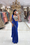 Full-length view of a designer royal blue concept saree with metallic coin borders and an embellished blouse, showcased in a premium bridal store setting.