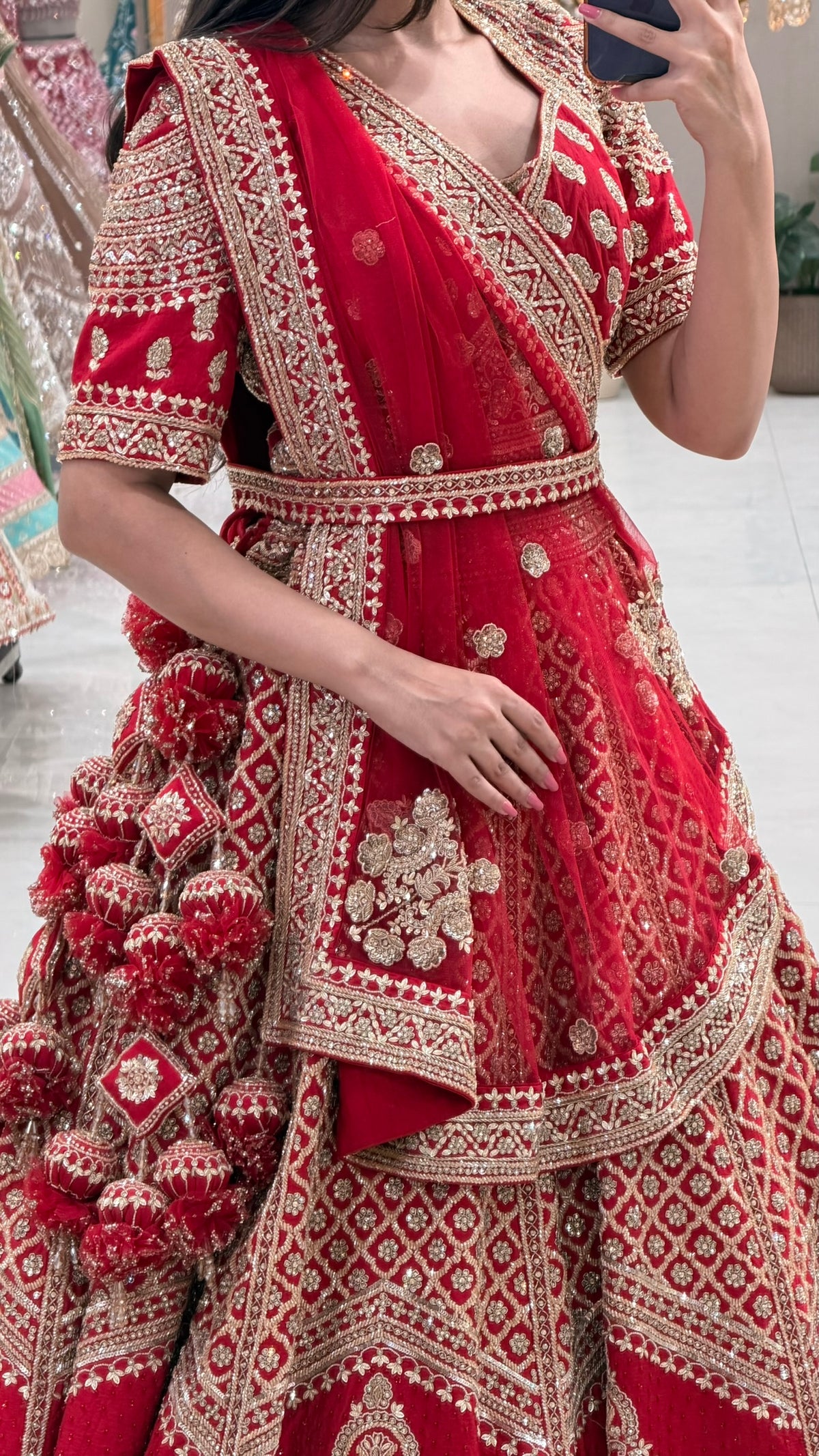 Luxury red bridal lehenga Pune – gold zardozi tiered skirt and wrap blouse at Urban Dulhaniya boutique.
Red bridal lehenga shop Pune MG Road Camp – traditional gold zardozi set at Urban Dulhaniya Oswal Plaza
