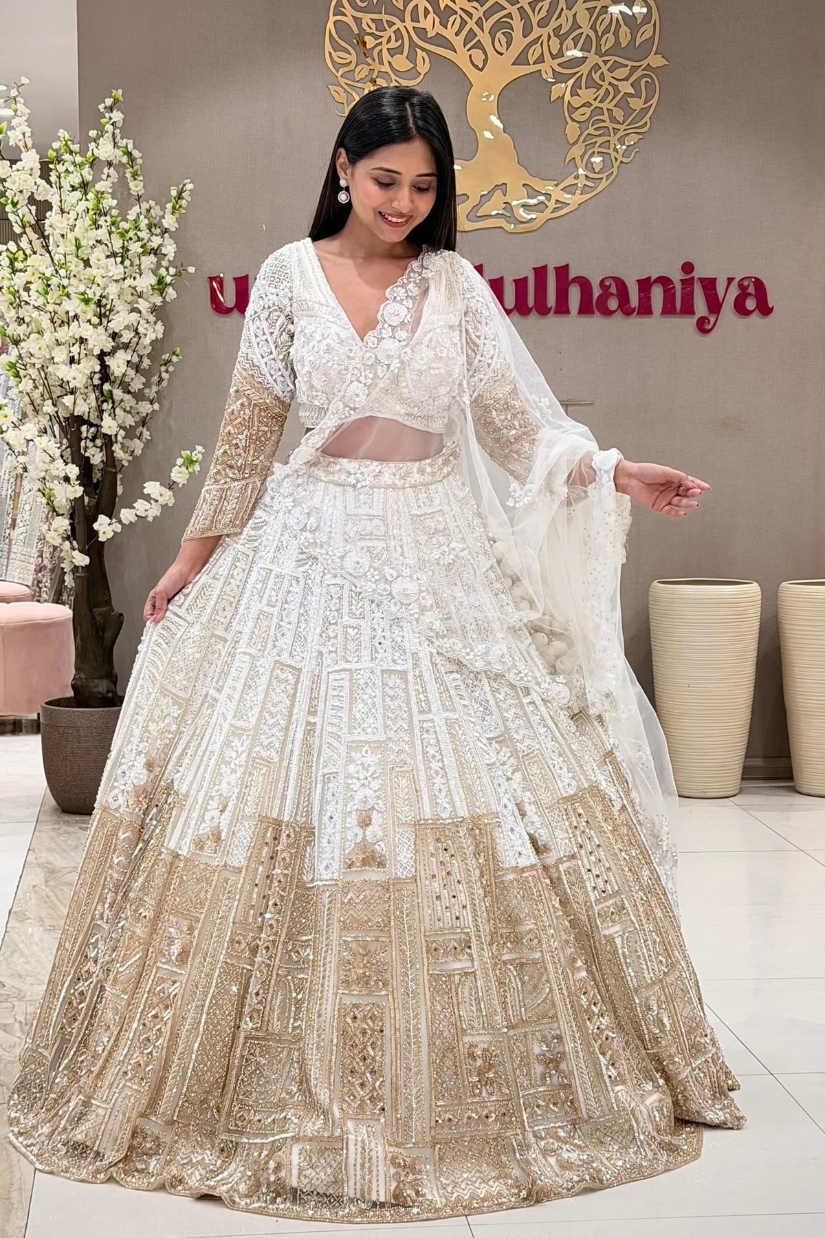 White Indian bridal lehenga with gold panel skirt – NRI bridal shopping at Urban Dulhaniya Pune.
Luxury white bridal lehenga Pune – geometric gold panel skirt and 3D blouse at Urban Dulhaniya boutique