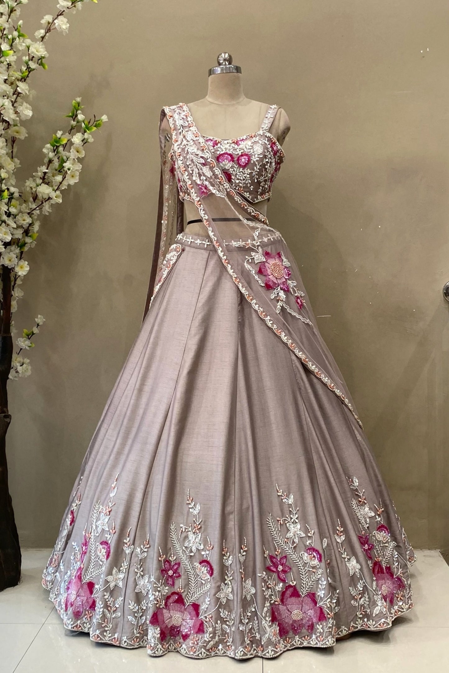 Detailed view of large floral motifs made with cut dana and poath moti on the border of a premium lehenga skirt.