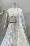 Close up of designer off-white V-neck embroidered lehenga blouse and matching sequin dupatta.