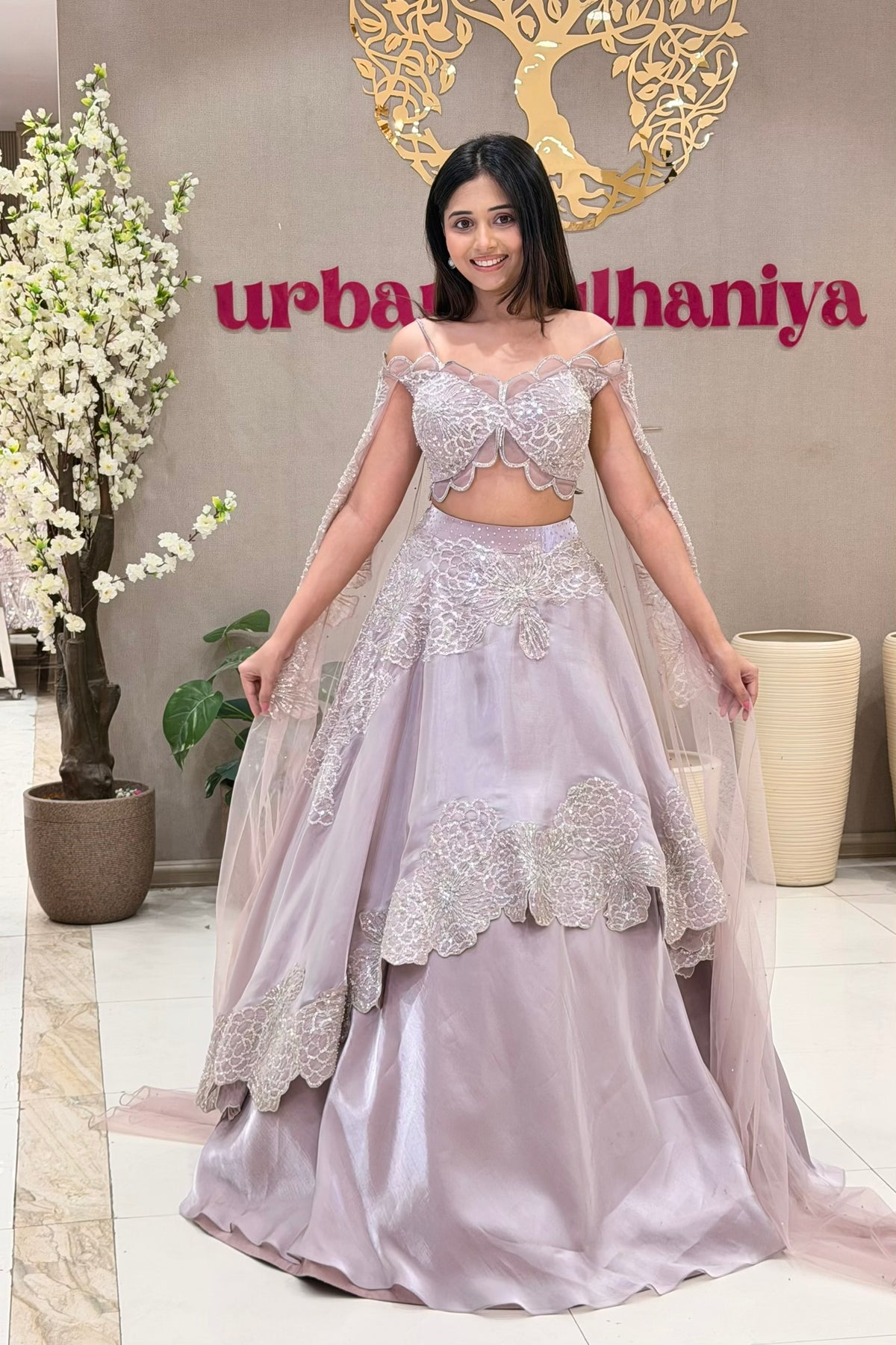 Luxury lavender butterfly lehenga Pune, silver floral appliqué and cape dupatta at Urban Dulhaniya.
Lavender reception lehenga with off-shoulder butterfly blouse and silver embroidery, Urban Dulhaniya Pune
