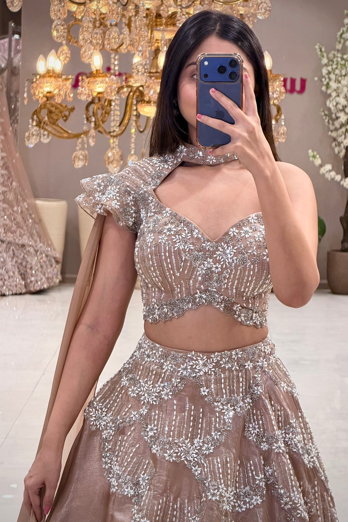 Nude champagne lehenga with one-shoulder choker blouse and white floral bead handwork, Urban Dulhaniya