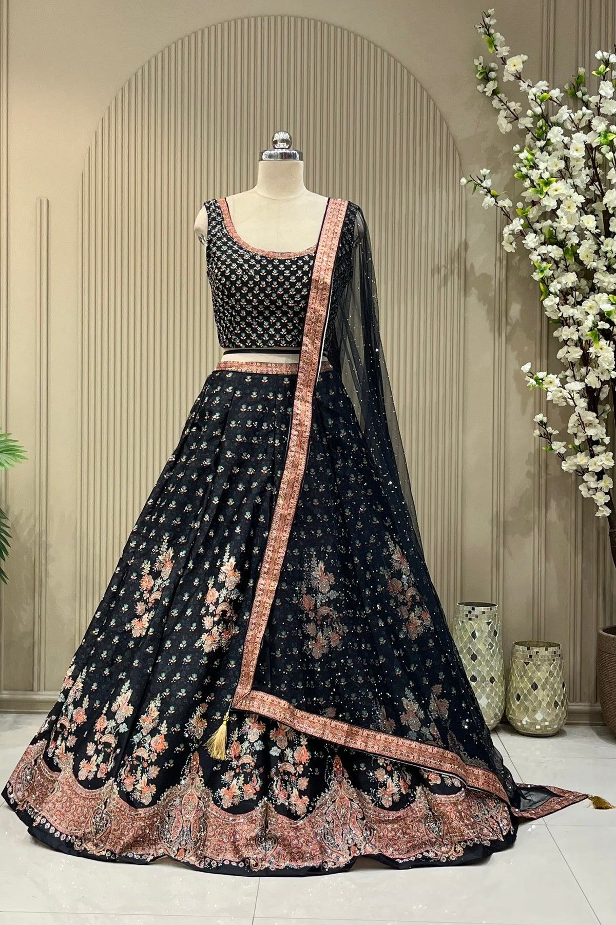 Black lehenga set showing scattered floral print and coral paisley border