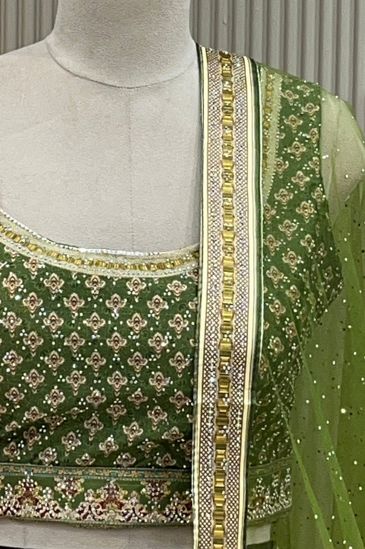 Close-up front view of printed blouse and lehenga waistband with lace trim