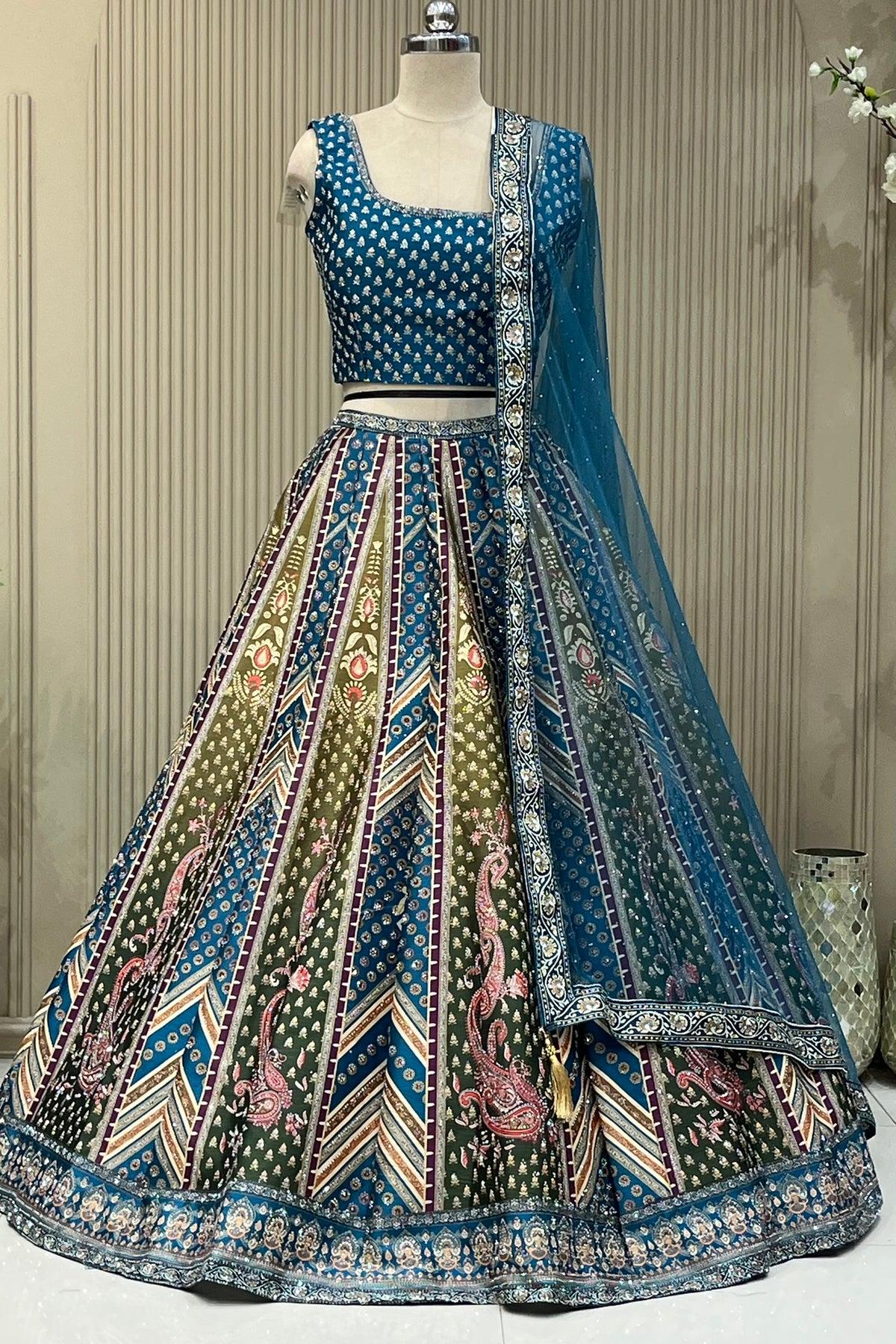 Close-up of teal blouse and paisley-bordered net dupatta detail
