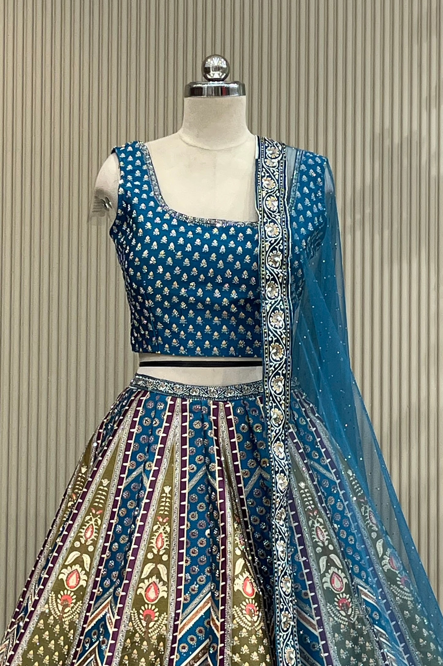 Teal chevron panelled lehenga set showing paisley motifs and multicolor panels