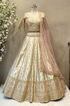 Detailed view of a flared ivory raw silk lehenga skirt featuring rich gold architectural zardosi embroidery and traditional motifs.