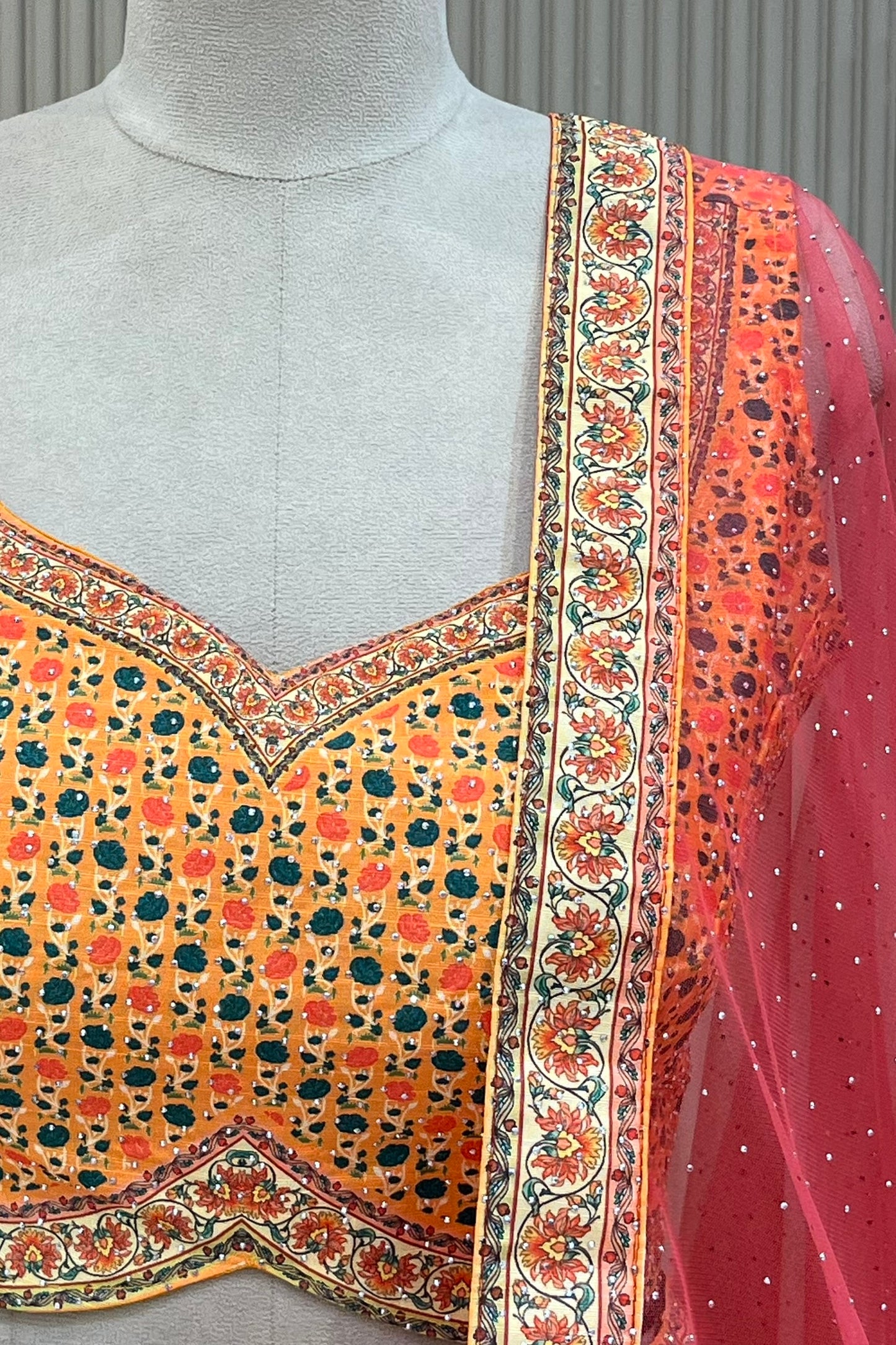  Close-up of mustard floral print blouse and rust net dupatta border with stone detail