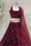 Close-up of a designer maroon sequin sleeveless lehenga blouse with a scoop neckline, paired with a sheer net dupatta for cocktail parties.