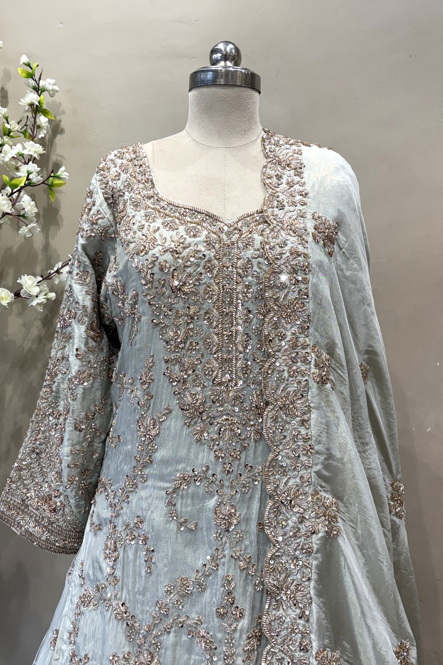 Luxury Indian bridal wear sage green kurti lehenga set modeled in a boutique setting.