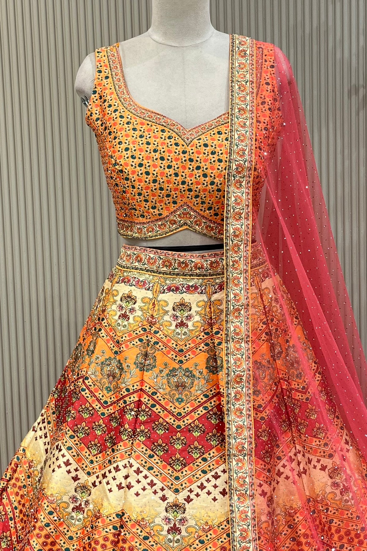 Multicolor lehenga set showing chevron print and dense floral scallop hem border