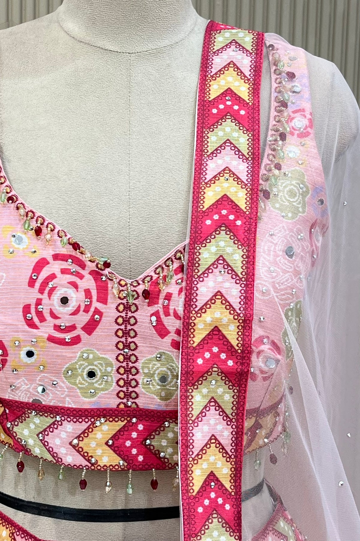 Close-up of mirror-work blouse, beaded tassel trim, and dupatta border