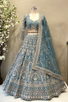 Detail shot highlighting the dense geometric sequin and crystal beadwork on a flared teal blue reception lehenga skirt.