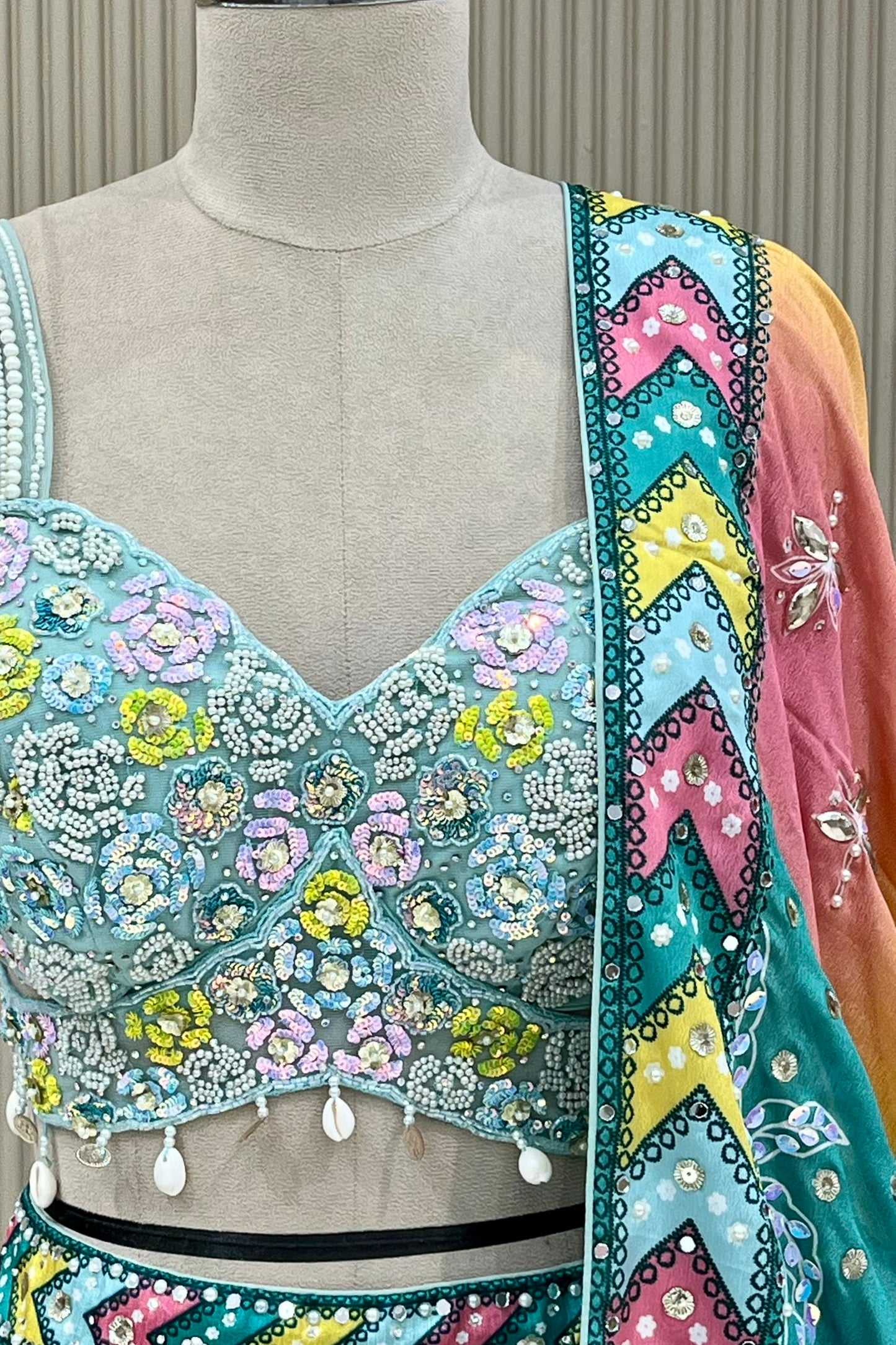 Close-up of blouse sequin, bead, and pearl floral embroidery with shell tassels and mirror border detail