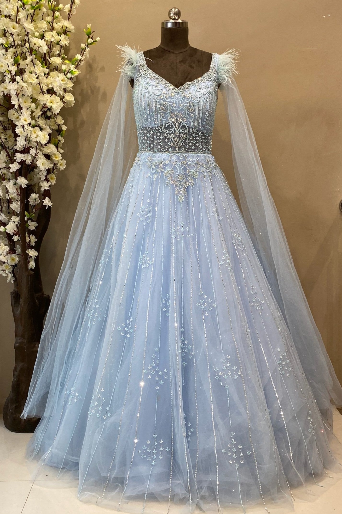 Beautifully hand crafted bridal gown in sky colour with selfie long sleeves and feather