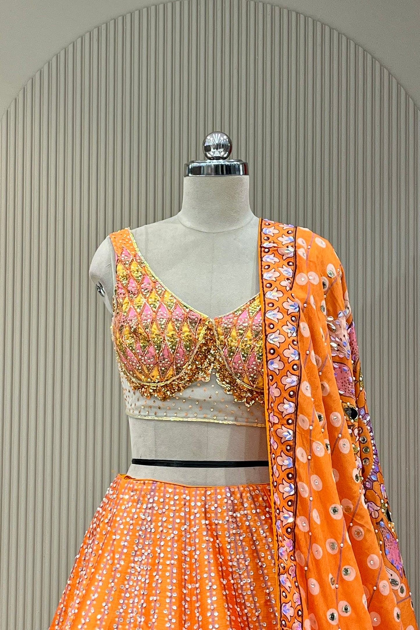 Detail shot of orange dupatta mirror border and sequin dot pattern