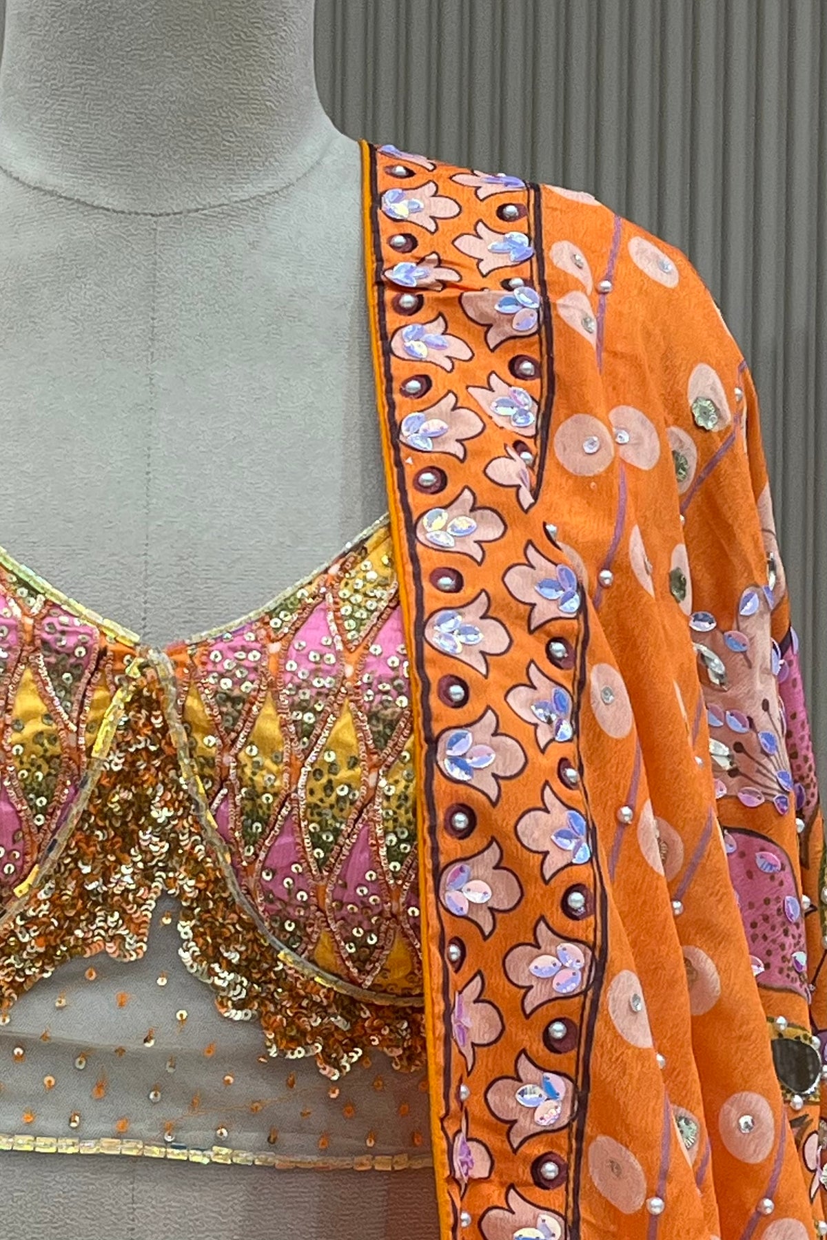 Close-up of orange sequin lattice hand-work blouse and floral medallion dupatta border