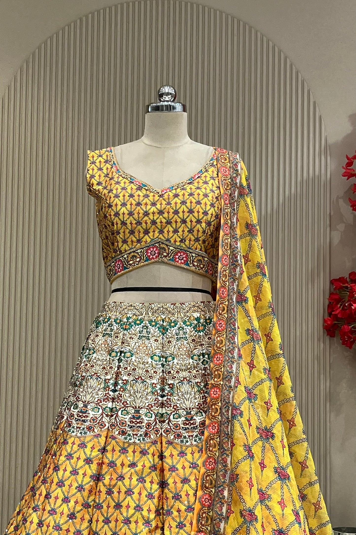 Close-up of mustard printed blouse and lehenga waistband showing floral contrast border