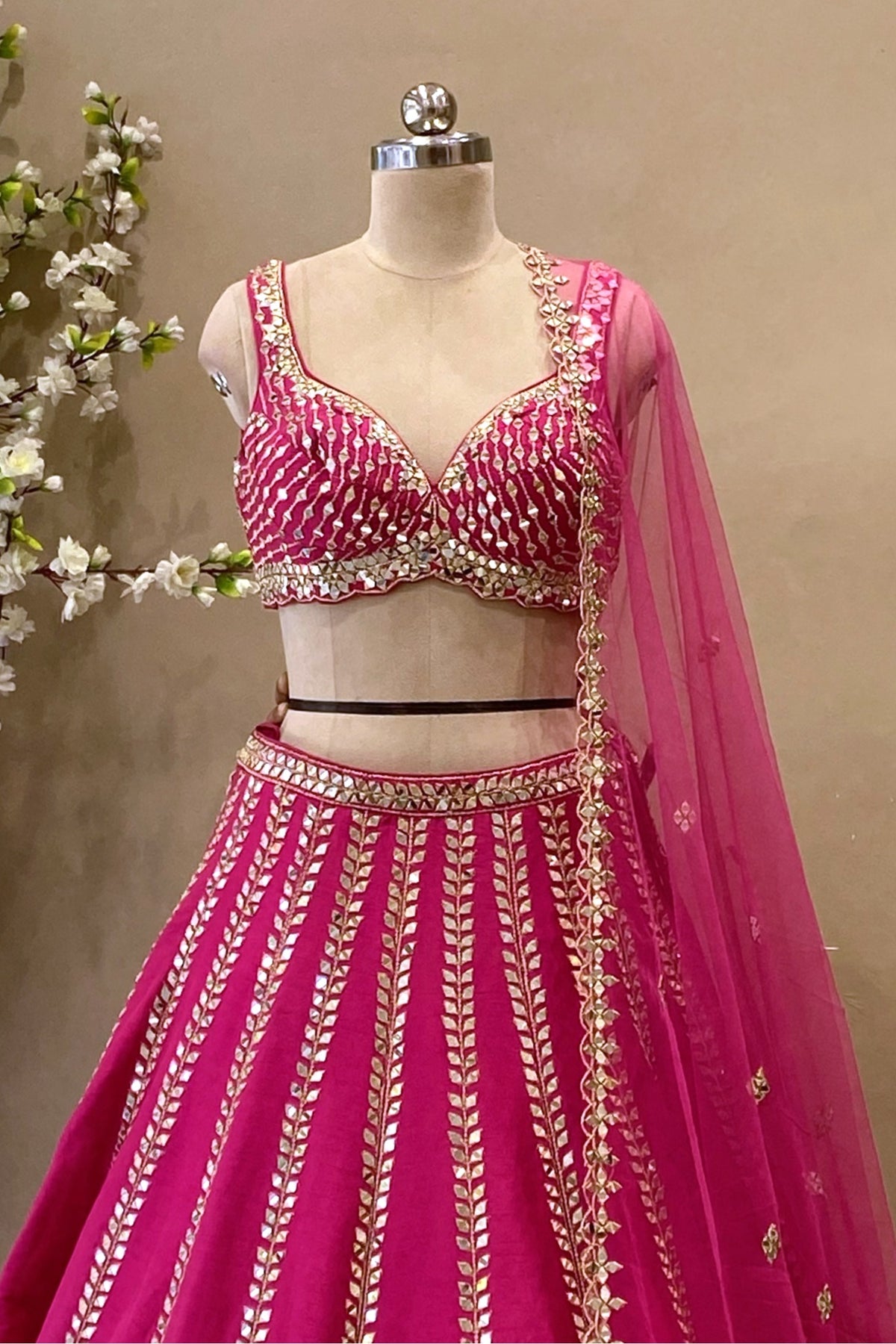 Detailed shot of a magenta designer lehenga skirt showcasing intricate Mirror work and a flared A-line silhouette.
