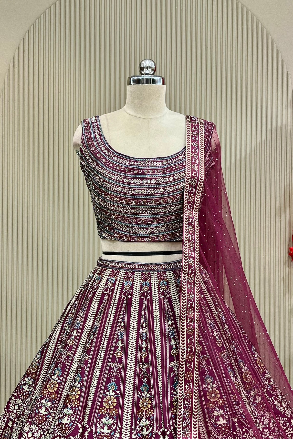 Close-up front view of printed blouse and lehenga waistband with net dupatta drape