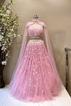Close-up of a luxury pink corset bodice with crystal beadwork, fringe hem, and sheer cape sleeves for a reception look.