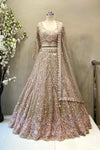 Detailed shot of a flared champagne and pink lehenga skirt featuring dense geometric beadwork and a heavy scalloped border.