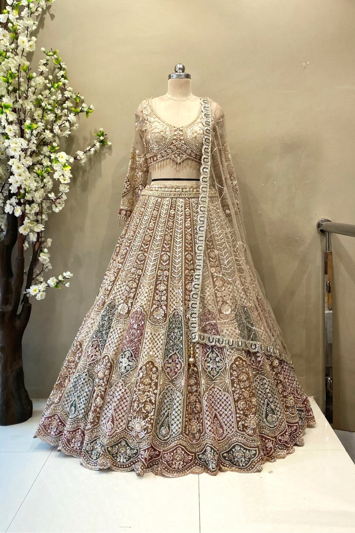 Full-length view of a luxury multi-color heavy beads work bridal lehenga with arched panel embroidery and a long-sleeve blouse at Urban Dulhaniya.
