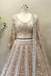 Detailed shot of a flared antique gold lehenga featuring dense multi-color heavy beads work and a wide scalloped border.