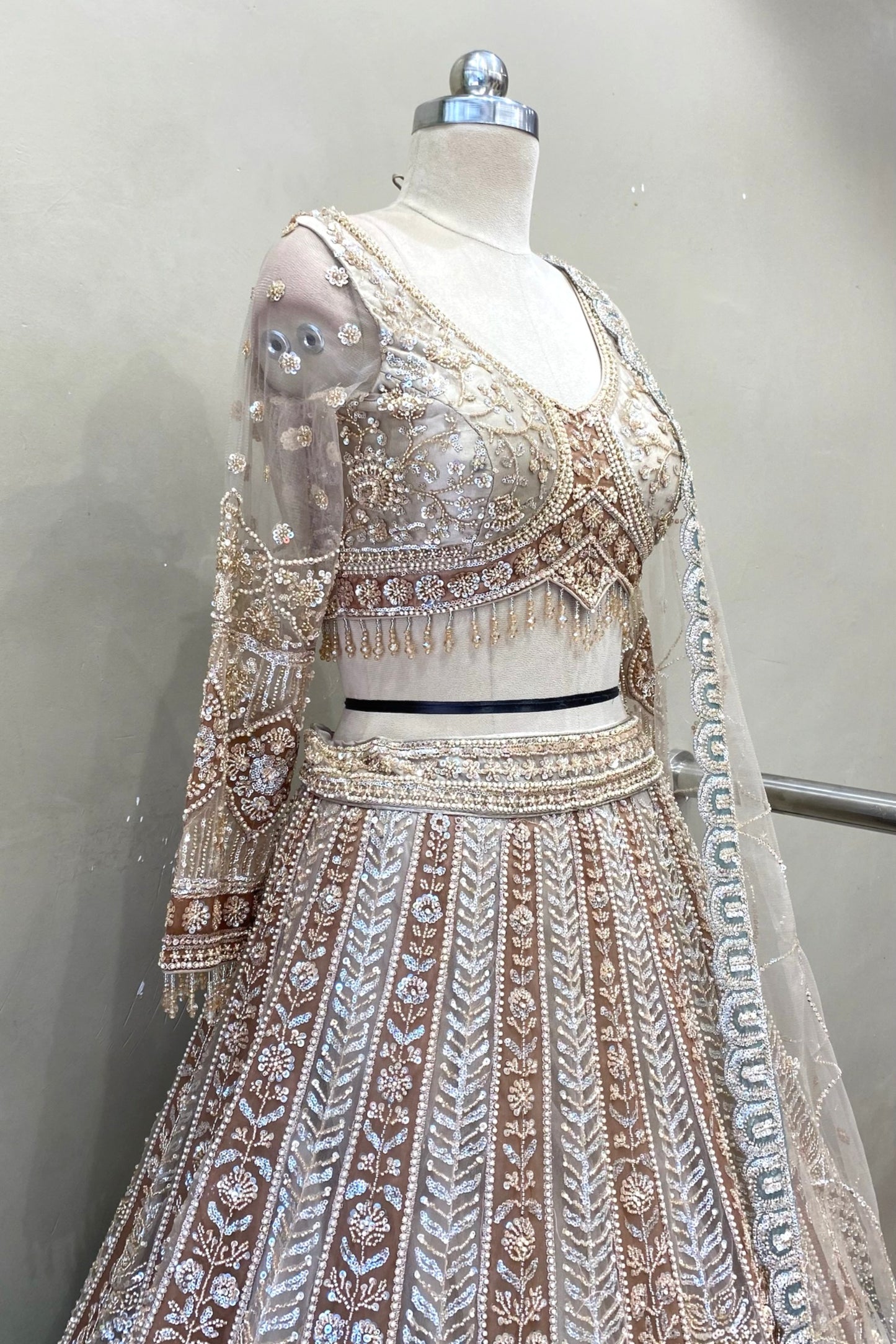 Side profile of a heavy beads work lehenga blouse showcasing the texture of the metallic beads and sheer sleeve craftsmanship.