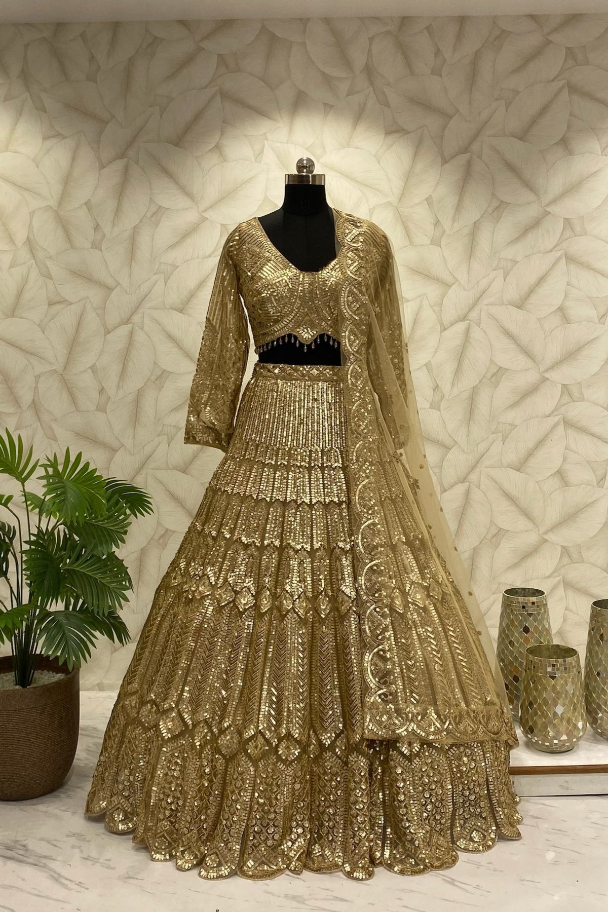 Front view of the Golden Dream designer lehenga featuring complete heavy fabrication work by Urban Dulhaniya
Close-up detail of premium heavy fabrication and embellishments on a luxurious gold evening lehenga.