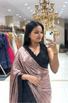 Close-up of a modern party wear saree featuring a liquid metallic pink pallu and a heavy black crystal embroidered V-neck blouse with scalloped borders.