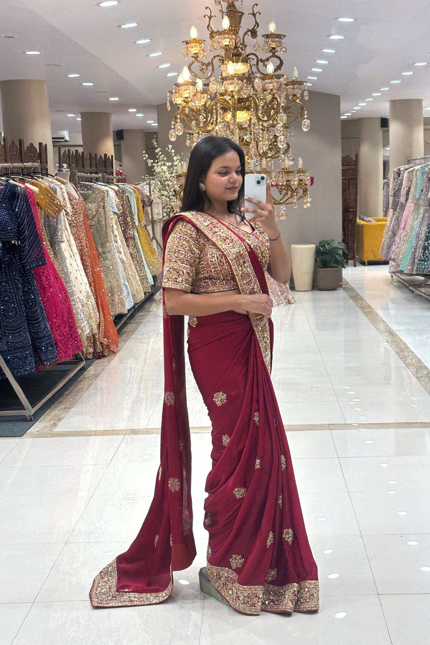 Full-length view of a luxurious deep maroon pure handwork designer saree with heavy gold borders, showcased at Urban Dulhaniya boutique in Pune.