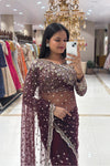 Close-up of a designer long-sleeve blouse featuring heavy pure handwork, crystal embellishments, and beaded tassels on a burgundy net reception saree.