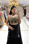 Close-up of a designer sheer black corset blouse featuring pure handwork gold bead and chain embellishments, paired with a ruched black mermaid skirt.