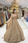 Full-length mirror selfie of a bride wearing a luxury champagne gold heavy handwork bridal lehenga with a scalloped dupatta at the Urban Dulhaniya boutique.