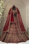 Deep maroon heritage bridal lehenga on a mannequin featuring antique gold zari, heavy dark red zarkan highlights, and a double dupatta styling.