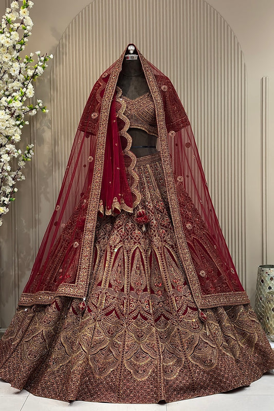 Deep maroon heritage bridal lehenga on a mannequin featuring antique gold zari, heavy dark red zarkan highlights, and a double dupatta styling.