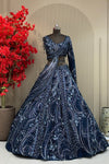 Midnight navy designer lehenga on a model featuring heavy hand-embroidery with cutdana, sequins, and metallic beads, paired with a modern sleeveless V-neck blouse.