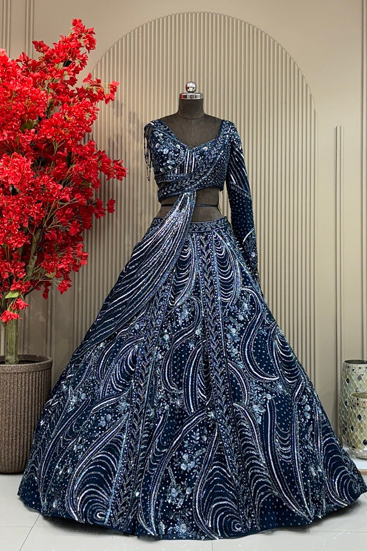 Midnight navy designer lehenga on a model featuring heavy hand-embroidery with cutdana, sequins, and metallic beads, paired with a modern sleeveless V-neck blouse.