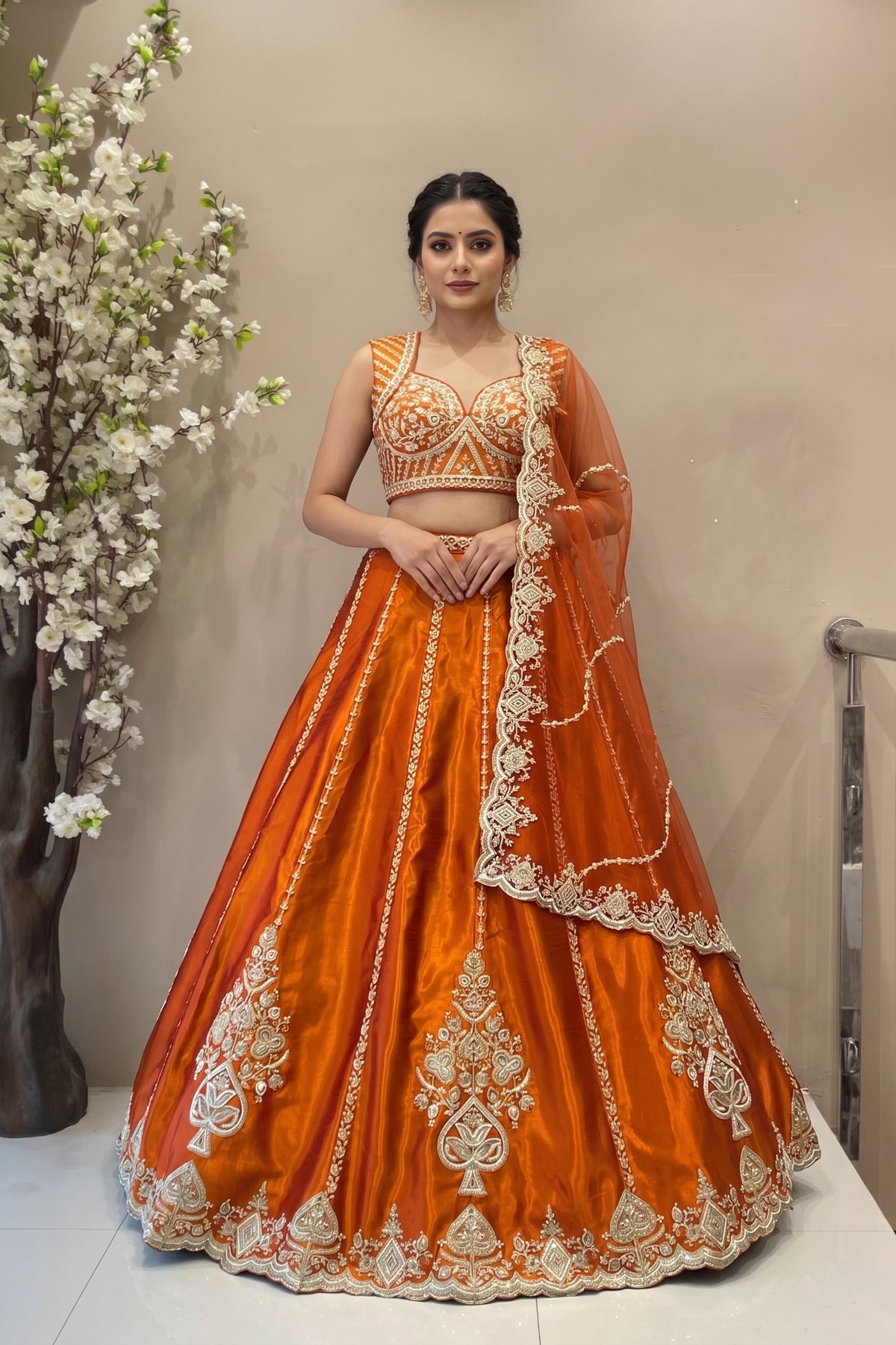 Tangerine orange raw silk lehenga set with vertical beadwork panels and scalloped dupatta for bridal wear.
